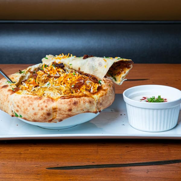 Spice Social's Indian biryani, baked in a bread bowl, with a side of raita.